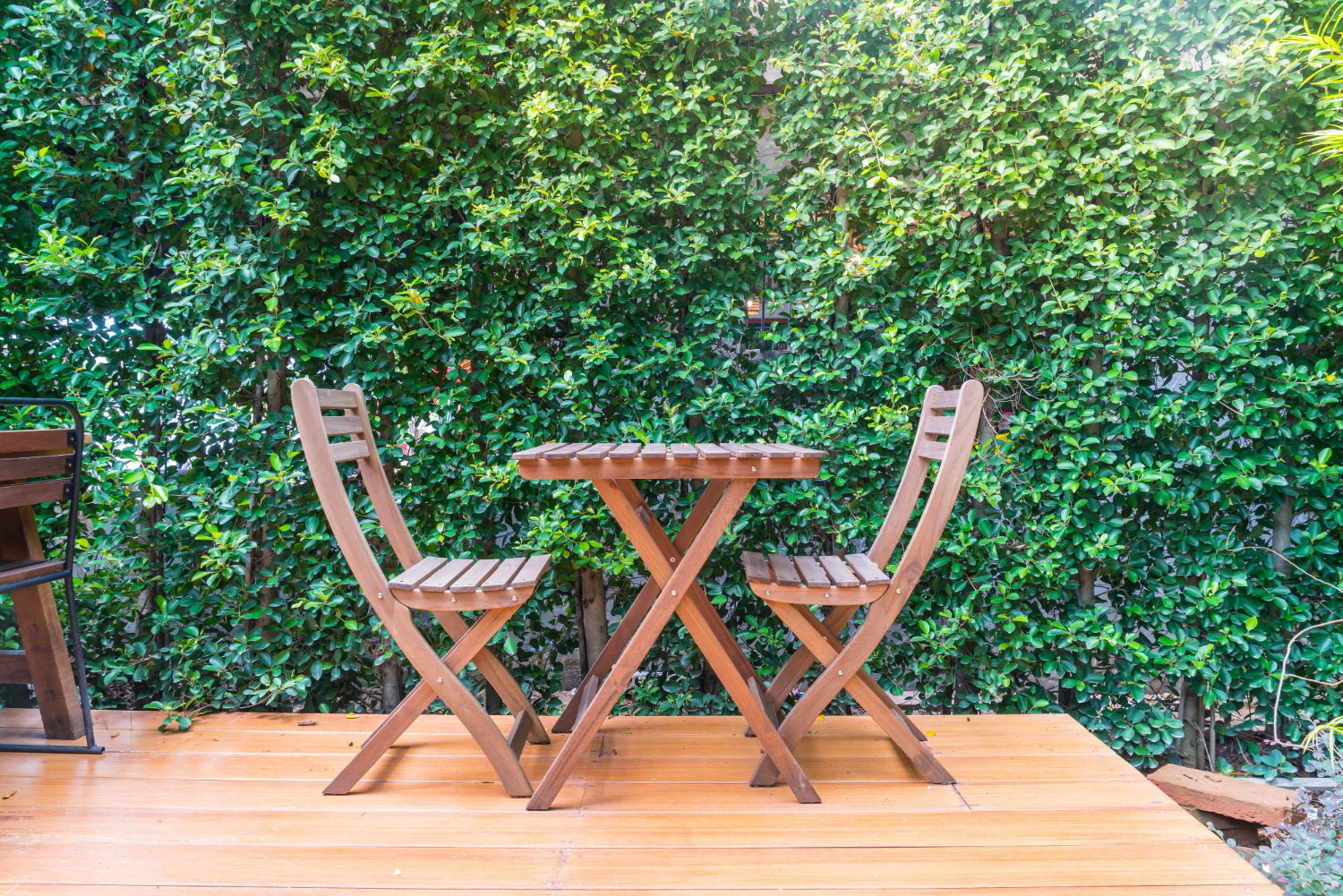 Table et chaises en bois sur terrasse extérieure.