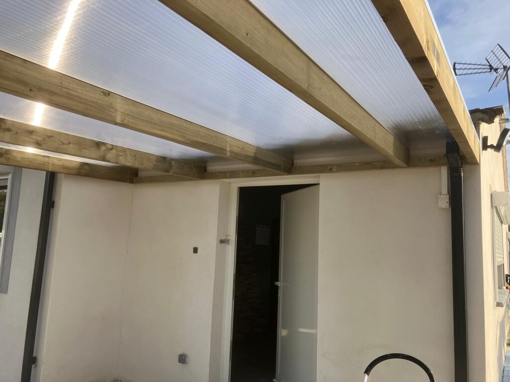 Installation d'une toiture en polycarbonate pour terrasse.