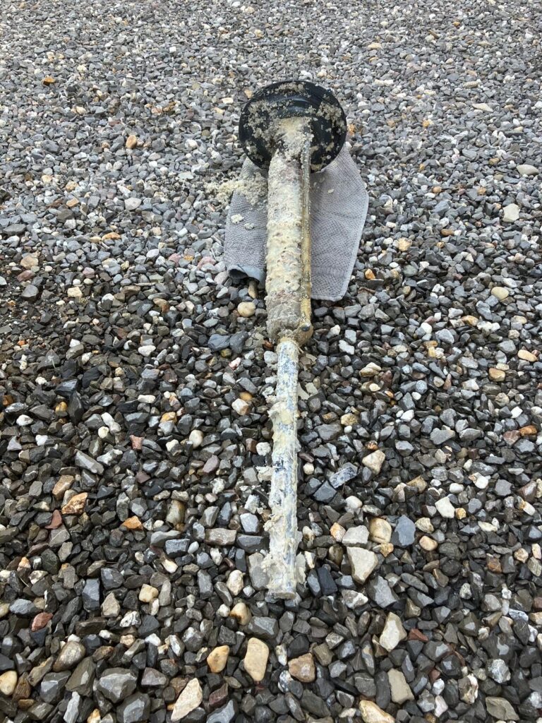 Pipe rouillé sur graviers.