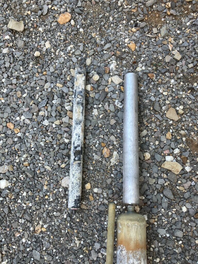 Deux poteaux métalliques sur gravier.