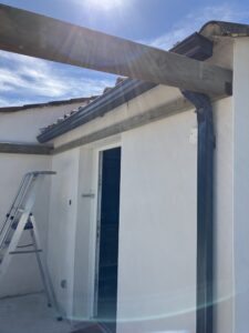 Toit en construction avec échelle et gouttière.